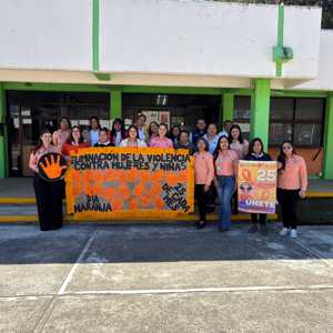 Personal del TecNM Huatusco posa frente a un edificio con una manta naranja que promueve la eliminación de la violencia contra mujeres y niñas. Los participantes visten de naranja y sostienen carteles alusivos al "Día Naranja" y la campaña "Únete", celebrada cada día 25 del mes.